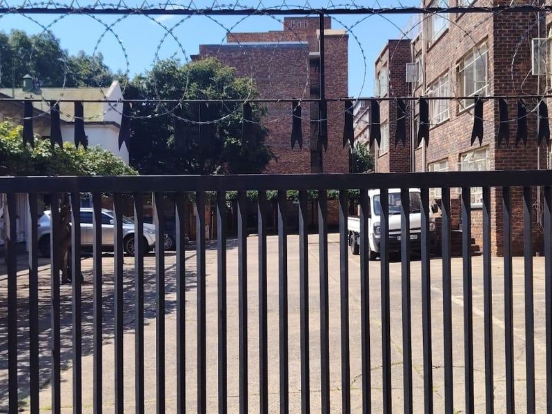 View of the apartment complex entrance featuring a secure gated driveway with brick facade buildings.