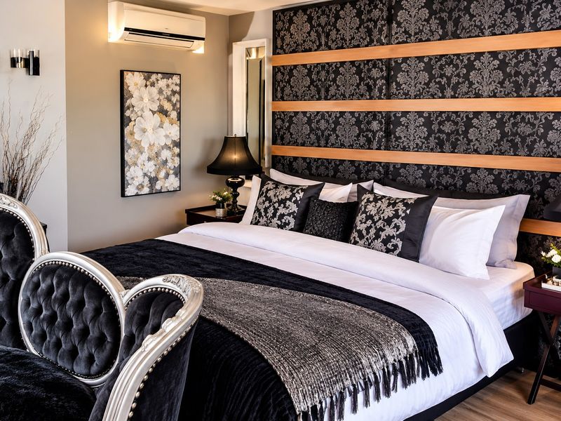 A well-appointed bedroom featuring a decorative wall-mounted headboard panel, split-system air conditioning, and modern laminate flooring.