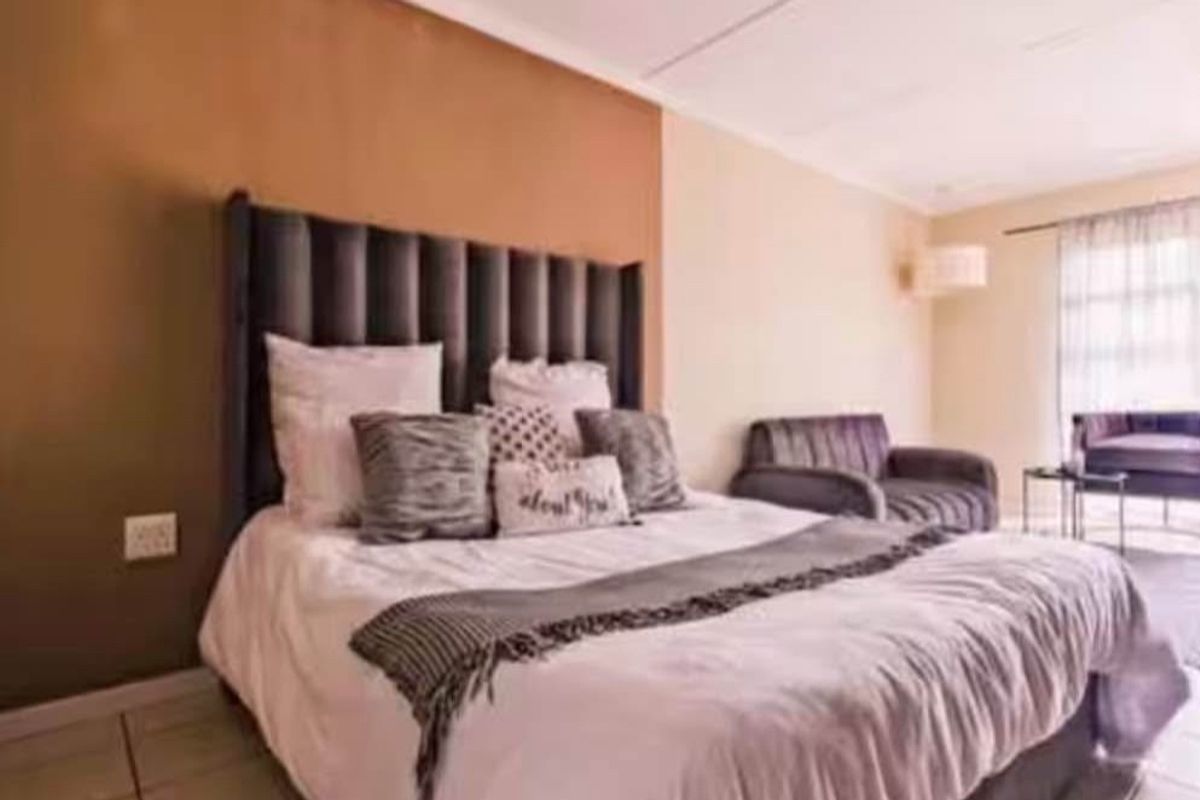 A spacious bedroom featuring tiled flooring and a sliding glass door providing natural light and access to the exterior.