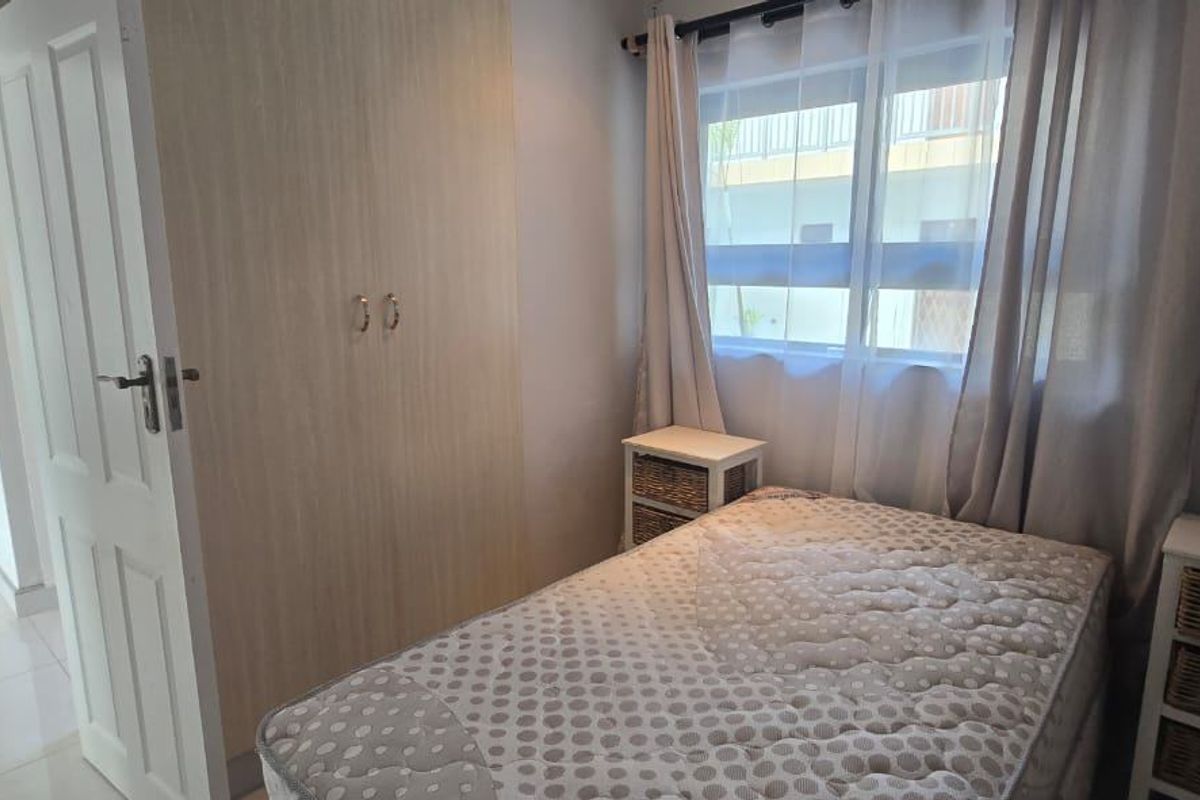 A compact bedroom featuring a built-in wardrobe and tiled flooring, offering a functional and well-maintained living space.