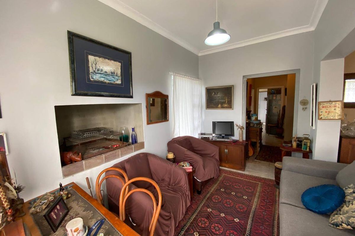 A cozy living room featuring a built-in fireplace, neutral wall tones, and classic cove cornicing, providing a comfortable and inviting atmosphere.