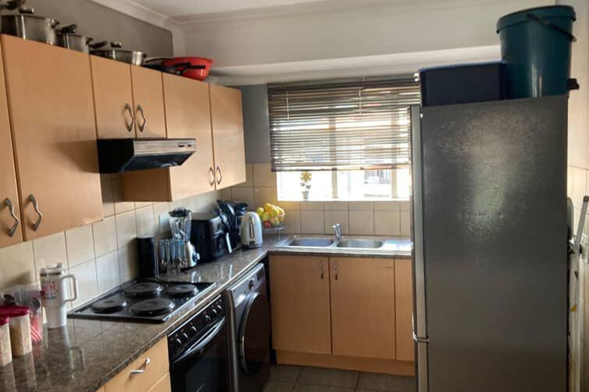A functional kitchen featuring laminate cabinetry, granite countertops, a double bowl sink, and built-in cooking appliances with a tiled backsplash.