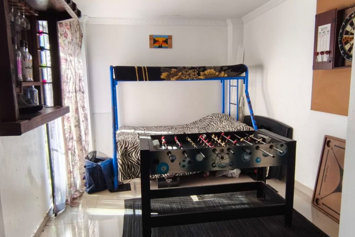 A bedroom space featuring tiled flooring and coving, currently utilized as a multi-purpose recreational area.