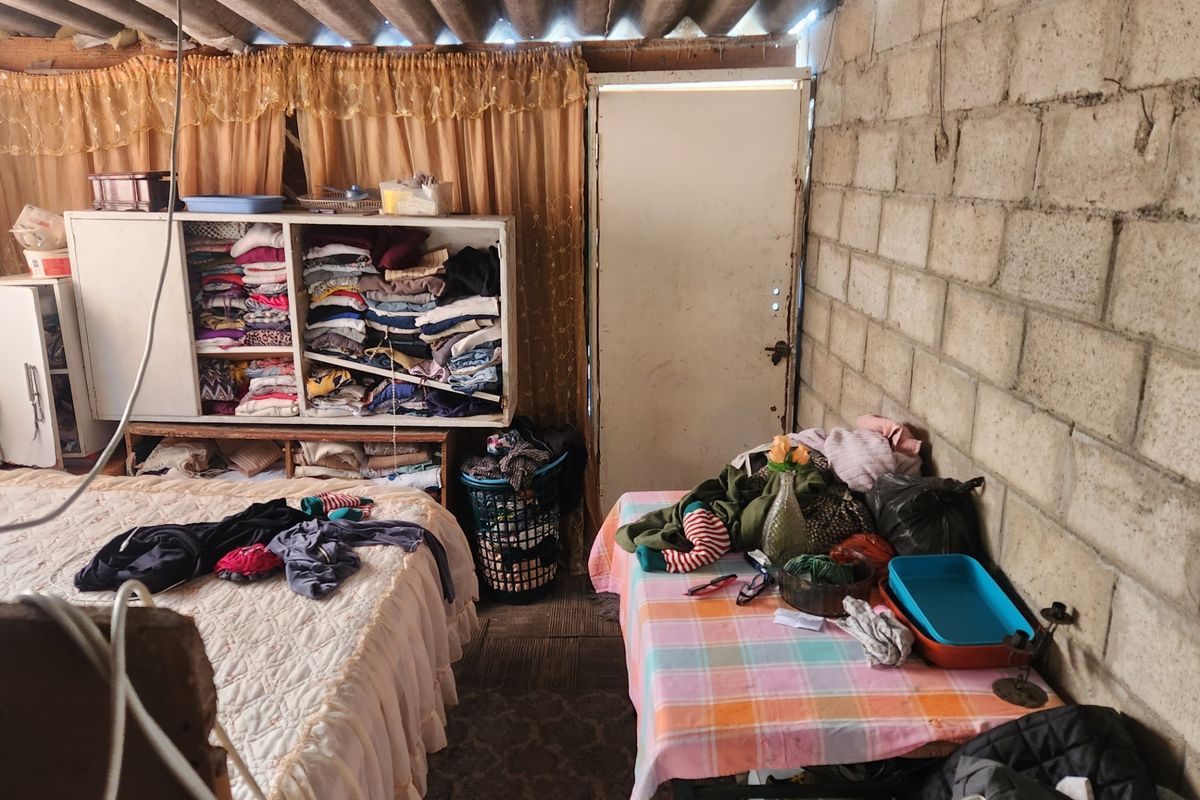 A bedroom featuring exposed concrete block walls and corrugated roofing, offering a rustic, unfinished aesthetic that could be enhanced with renovation.