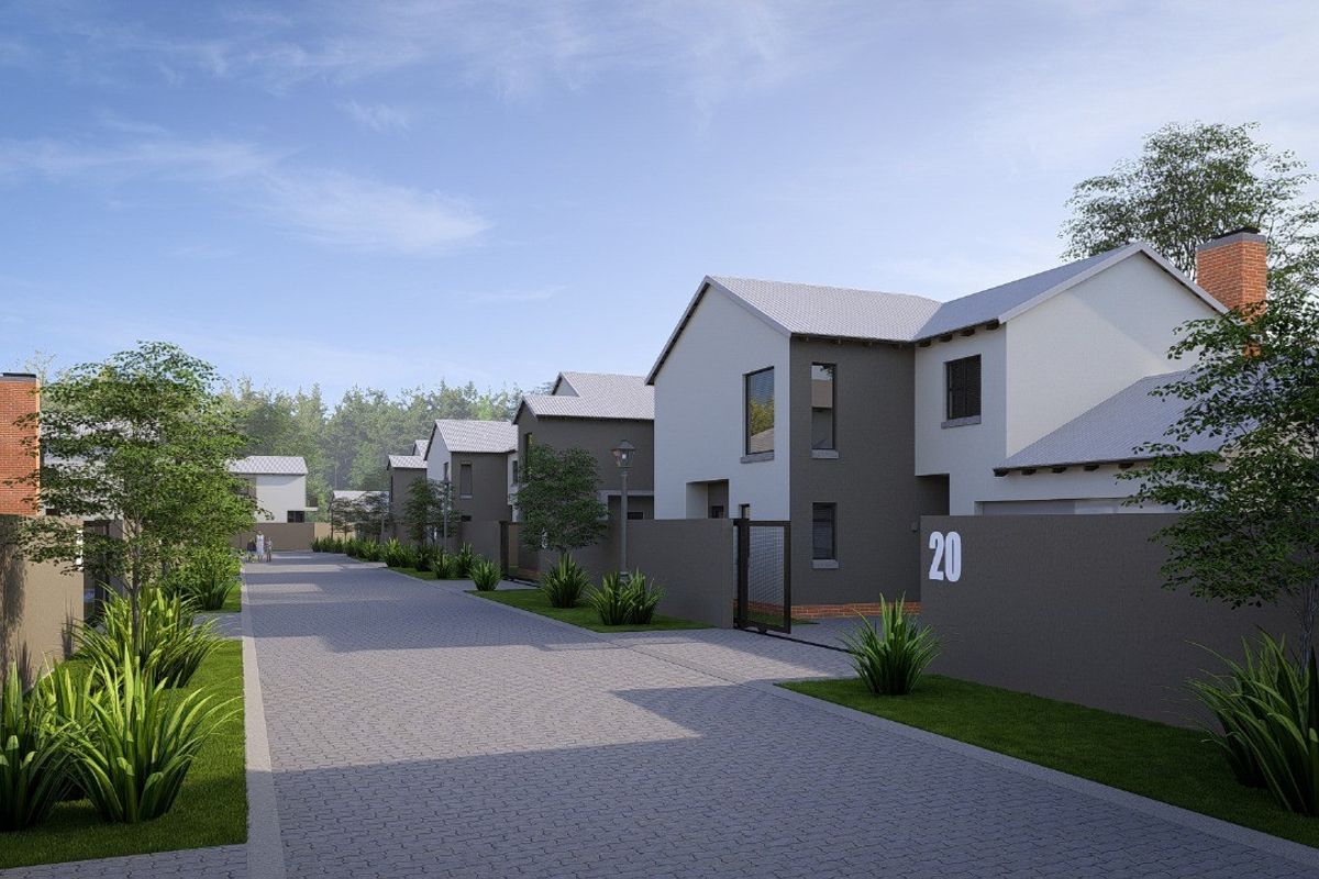 A street view of a modern residential complex featuring paved driveways, landscaped gardens, and contemporary house facades.