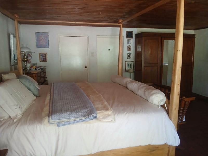 A bedroom featuring a timber ceiling and built-in wardrobe storage.