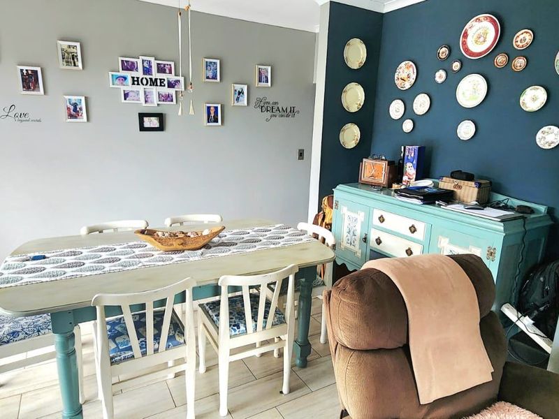 A dining area featuring tiled flooring and a contrasting dark blue accent wall, providing a functional space for meals and gatherings.