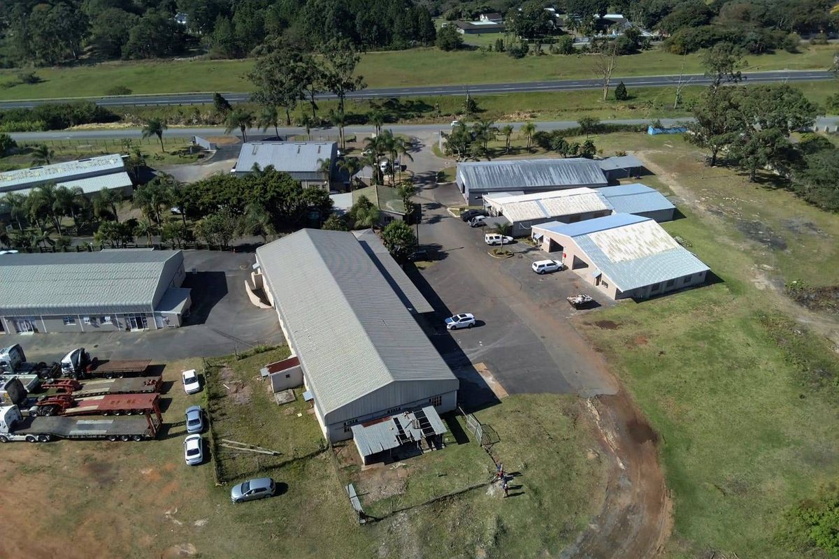 Aerial view of an industrial property complex featuring multiple warehouse buildings, paved access areas, and surrounding grounds.