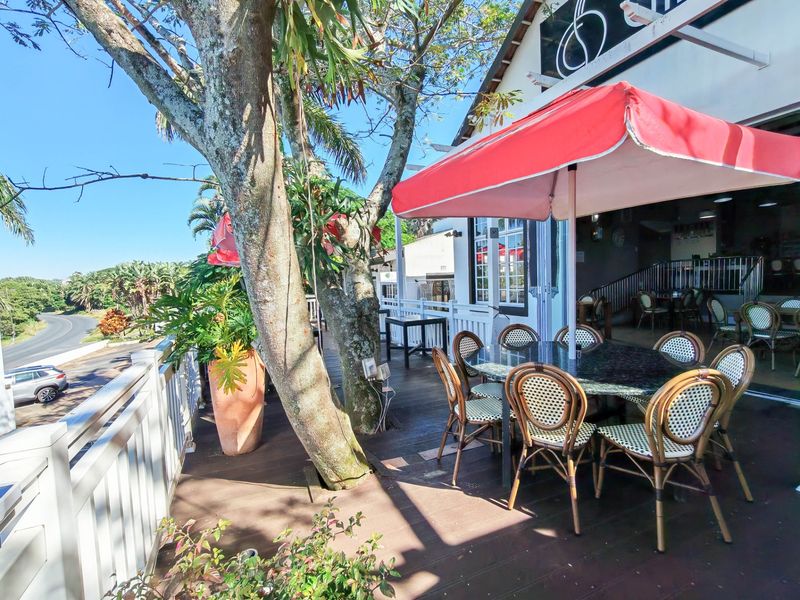 A spacious outdoor timber deck patio area featuring integrated railing and mature trees, providing an inviting space for commercial dining or relaxation.
