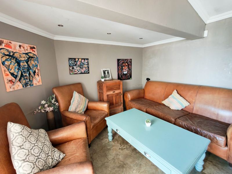 A cozy living area featuring polished concrete floors, recessed downlighting, and coved ceiling details, providing a neutral foundation for interior design.