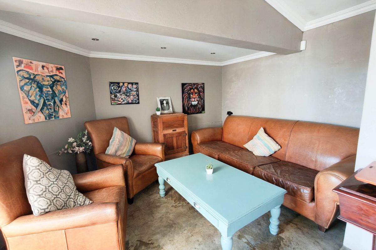 A cozy living area featuring polished concrete flooring, recessed downlighting, and coved ceiling details, providing a neutral foundation for interior design updates.