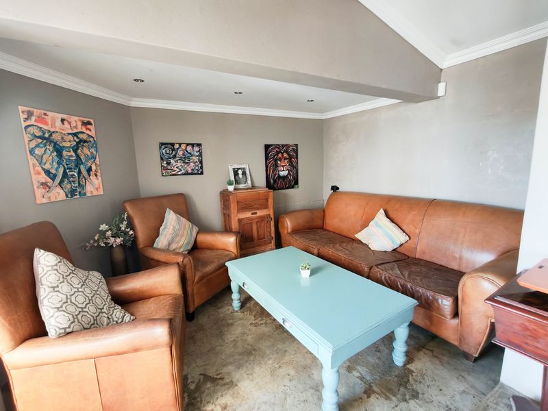 A cozy living area featuring polished concrete flooring, recessed downlighting, and coved ceiling details, providing a neutral foundation for interior design updates.