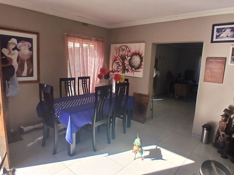 A dining area featuring tiled flooring and a timber entrance door, providing a functional space for family meals.
