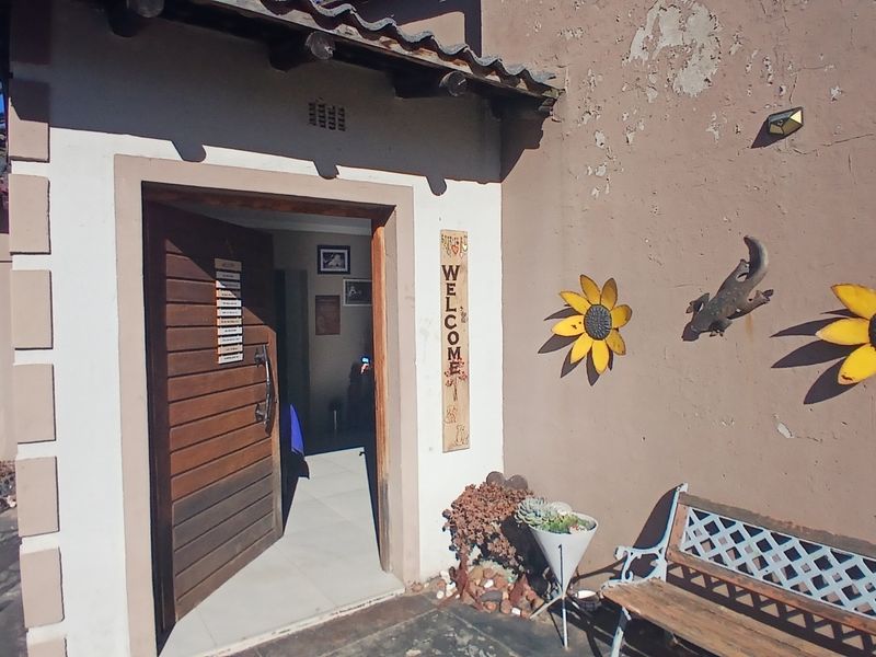 Entrance area featuring a wooden door and tiled flooring, with visible exterior wall maintenance required.