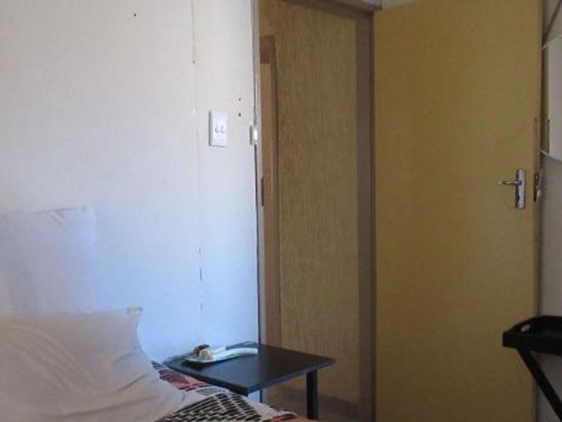 A bedroom interior featuring a standard internal door and basic wall finishes, showing signs of wear and tear.