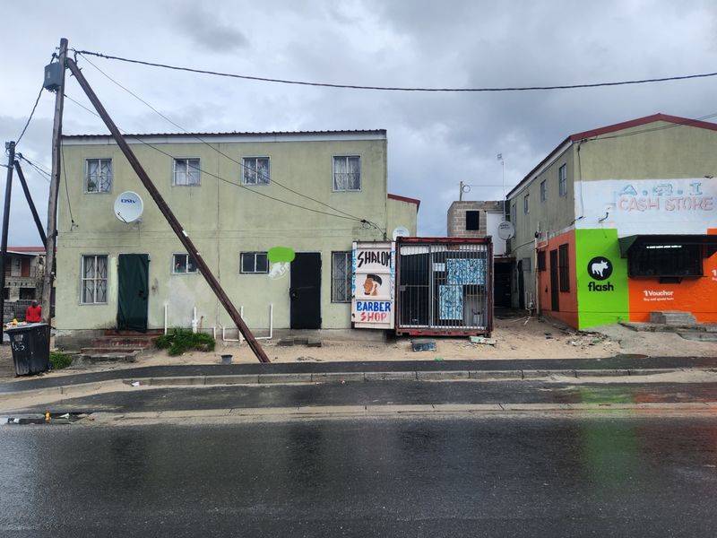 Street-level view of a multi-unit residential and commercial building featuring a mix of residential living spaces and ground-floor shopfronts.