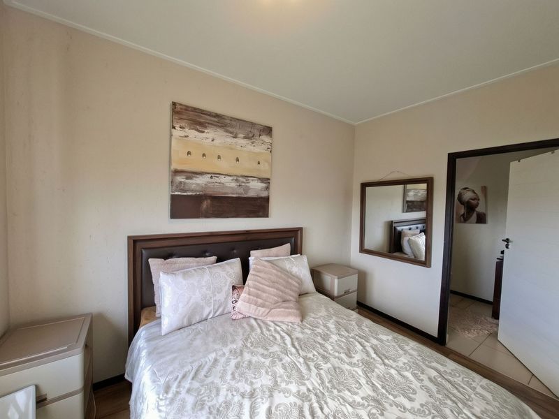 A bedroom featuring laminate flooring and neutral wall finishes, providing a functional and comfortable sleeping space.