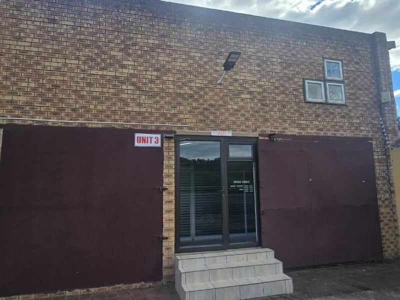 Front exterior view of commercial Unit 3, featuring a face brick facade, secure metal shutters, and an aluminium glass entrance door with tiled steps.