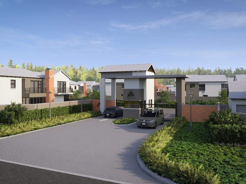 A modern residential estate entrance featuring a secure gatehouse, paved driveway, and contemporary architectural housing units.