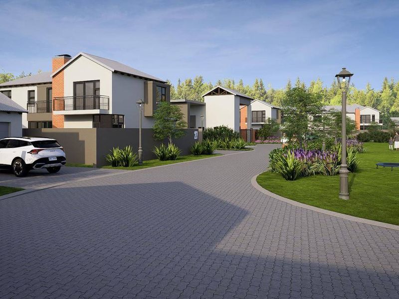 A street view of a modern residential estate featuring paved driveways, landscaped green spaces, and contemporary architectural house designs.