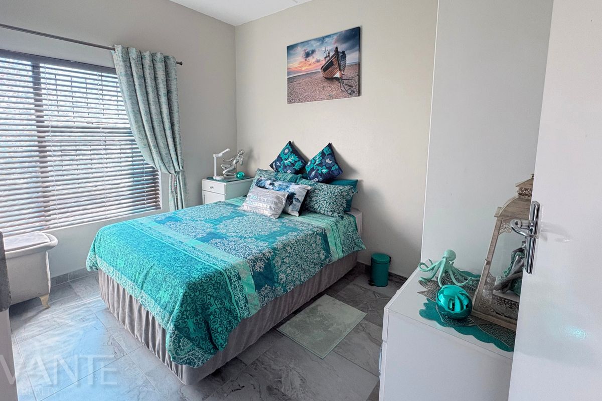 A well-maintained bedroom featuring tiled flooring and venetian blinds, offering a clean and functional space.