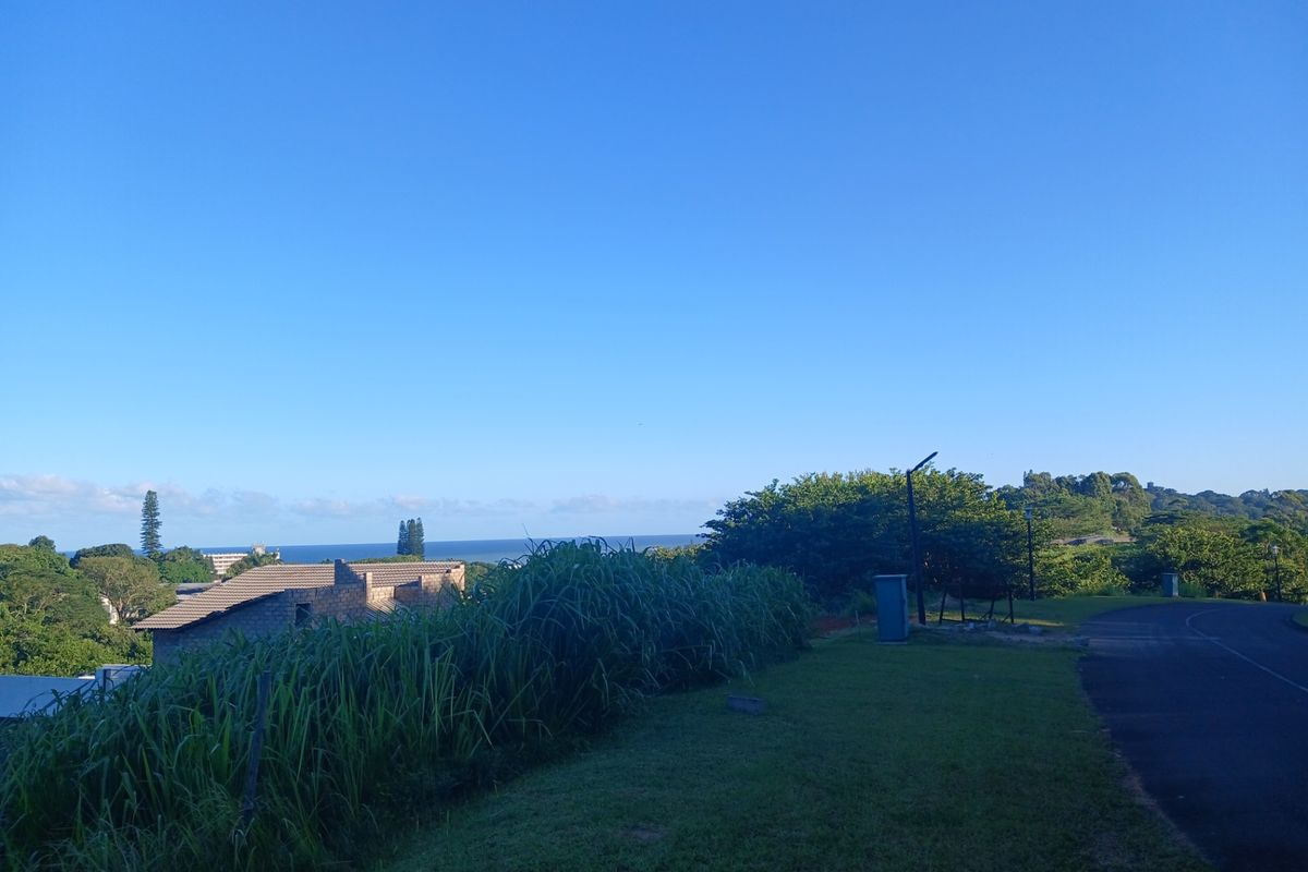 A scenic view overlooking the surrounding landscape and distant ocean horizon from the residential street level.