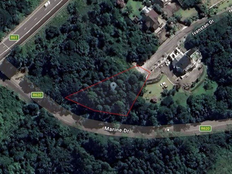 An aerial view of a vacant residential plot surrounded by dense vegetation, located near Marine Drive and Ivanstan Drive.