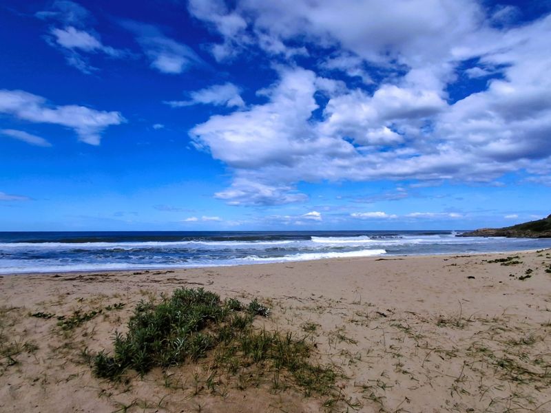 A scenic view of the sandy coastline and ocean waves, highlighting the natural beauty and direct beach access of the property.