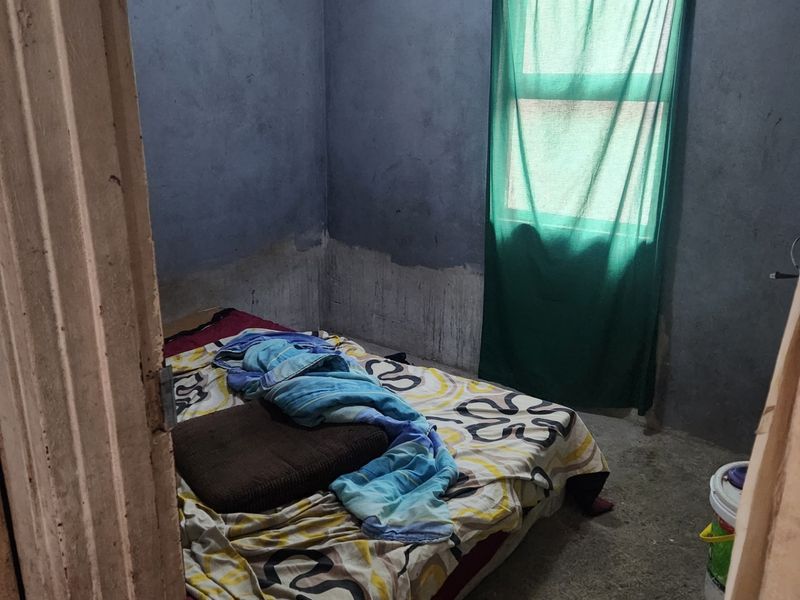 A bedroom featuring unfinished wall surfaces and exposed concrete flooring, requiring significant renovation and finishing work to improve its condition.