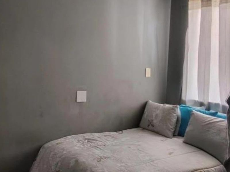 A compact bedroom featuring grey painted walls, a ceiling light fixture, and coving detail.