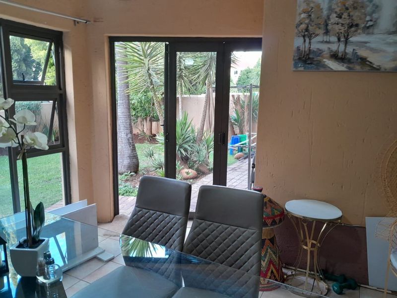 Dining area featuring tiled floors and large aluminium framed doors providing direct access to the garden.