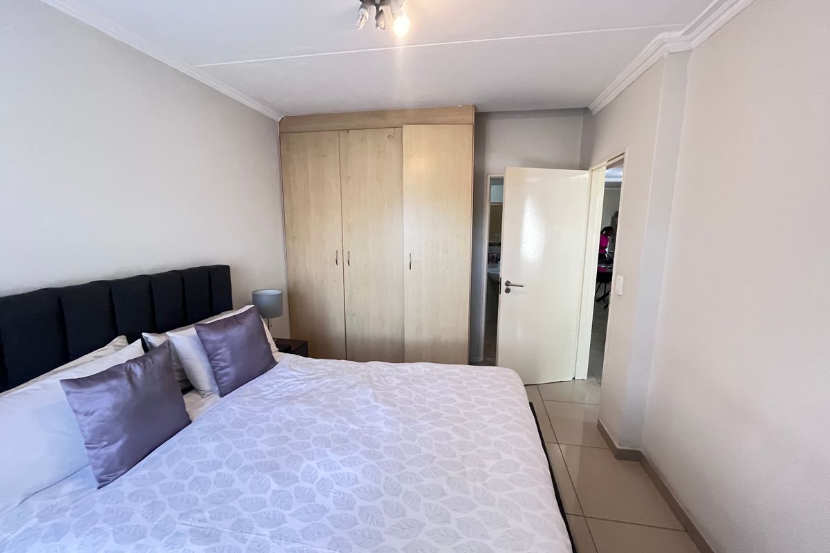 A bedroom featuring tiled flooring, a built-in wardrobe, and ceiling cornice detailing.