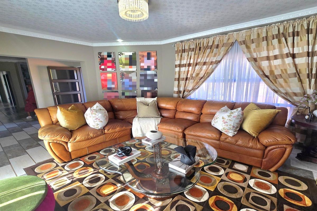 A spacious living room featuring tiled flooring, decorative crown molding, and a central ceiling light fixture, providing a comfortable and functional family living space.