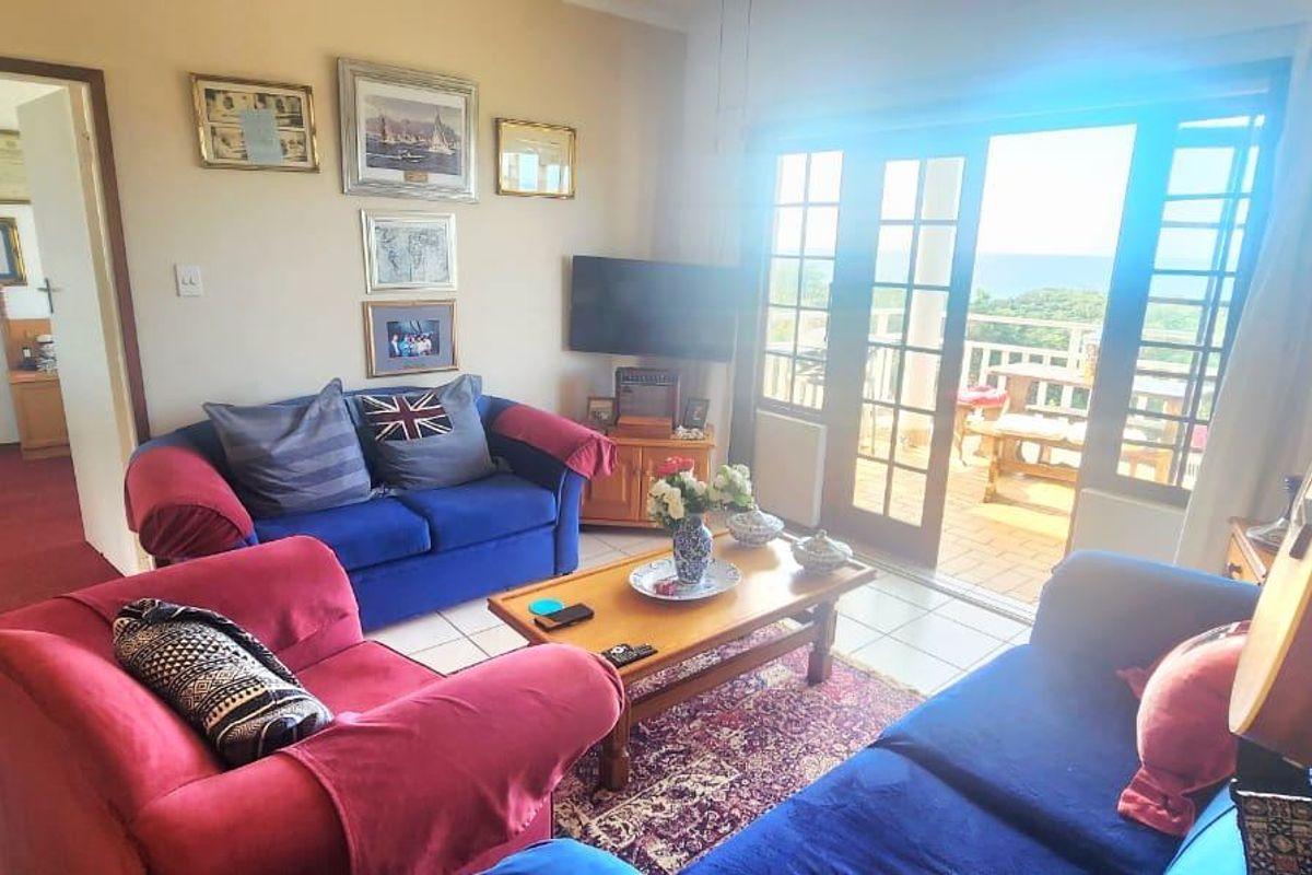 A living room featuring tiled flooring and french doors that provide direct access to an outdoor balcony area.