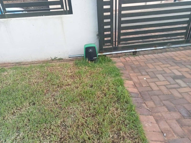 A view of the property's sliding gate motor mechanism installed on the driveway entrance.
