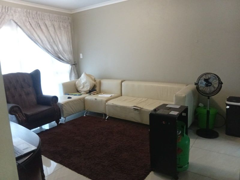A living room area featuring tiled flooring and neutral wall finishes, providing a functional space for relaxation.