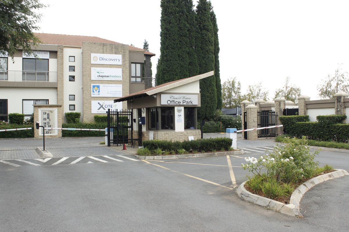 The entrance to Clear Water Office Park featuring a security guard house, boom gate access control, and well-maintained landscaped grounds.