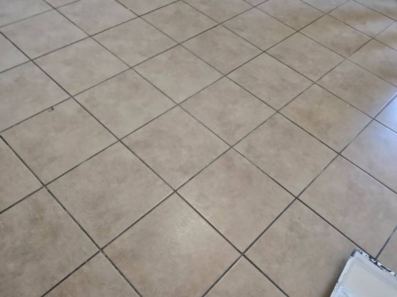 A view of a vacant room featuring neutral ceramic floor tiles and matching tiled skirting boards.