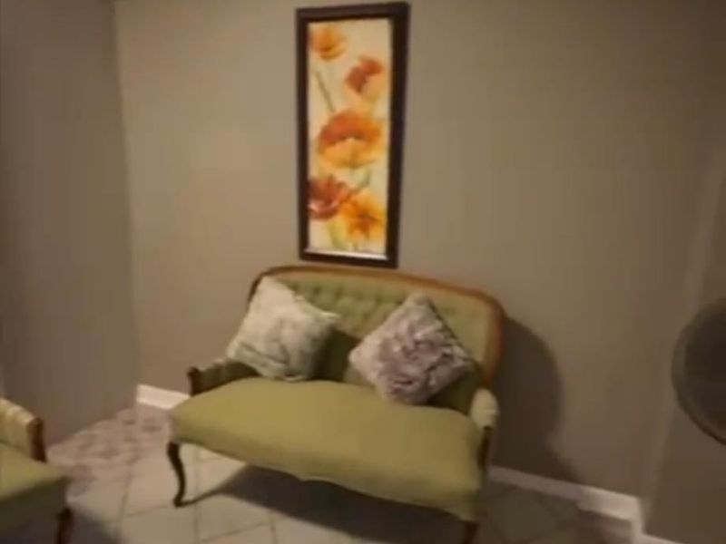 A living room area featuring tiled flooring and neutral wall tones, providing a functional space for relaxation.