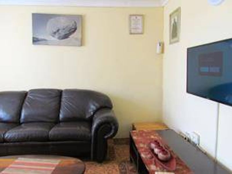 A standard living room area featuring a wall-mounted television and neutral wall finishes.