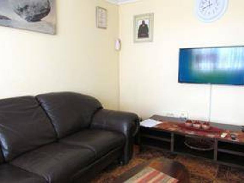 A living room area featuring a wall-mounted television and standard electrical fixtures.