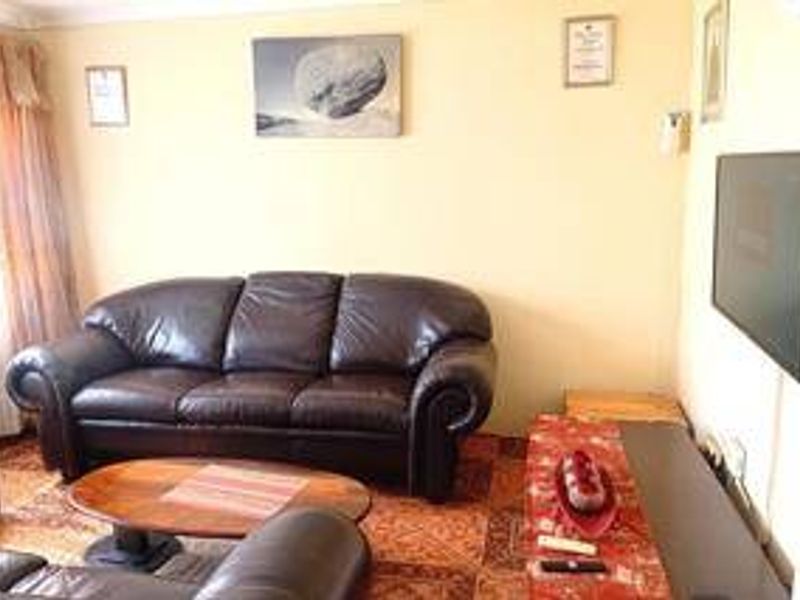 A living room featuring a wall-mounted television and neutral wall finishes.