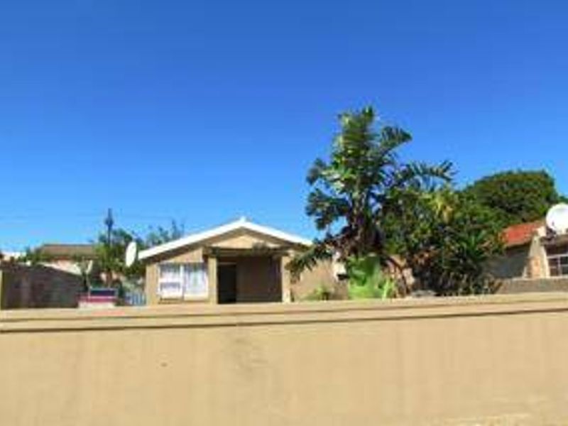 Front view of a single-story residential house featuring a solid boundary wall and a covered entrance area.