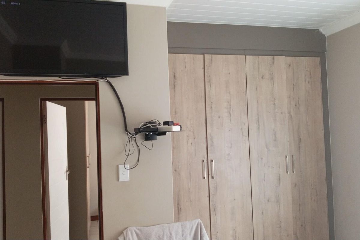 Bedroom featuring light wood-finish built-in cupboards and a white tongue and groove ceiling.