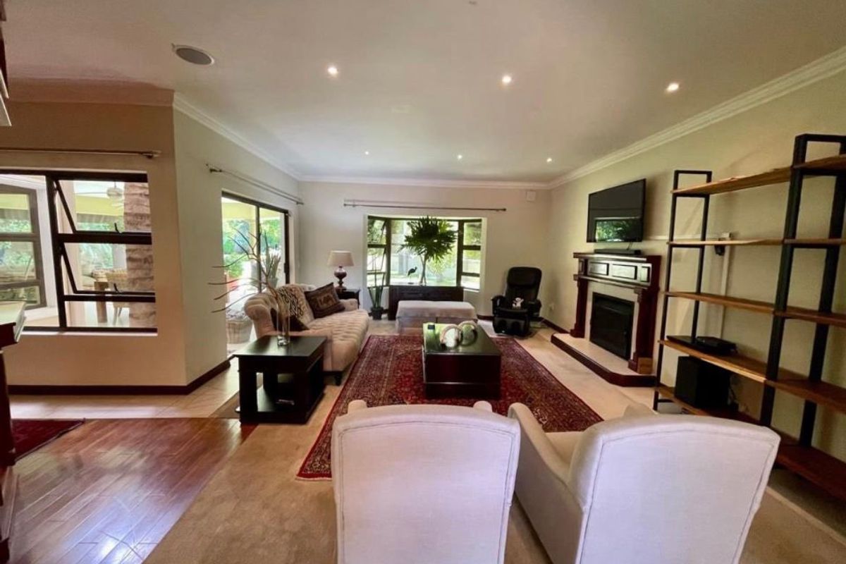 Spacious living room featuring a fireplace, recessed lighting, and large windows that provide natural light and access to the outdoor patio area.