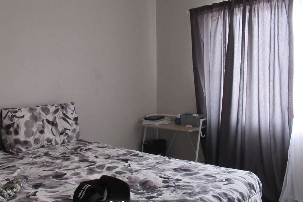 A standard bedroom featuring neutral wall finishes and window treatments, providing a functional space for rest.