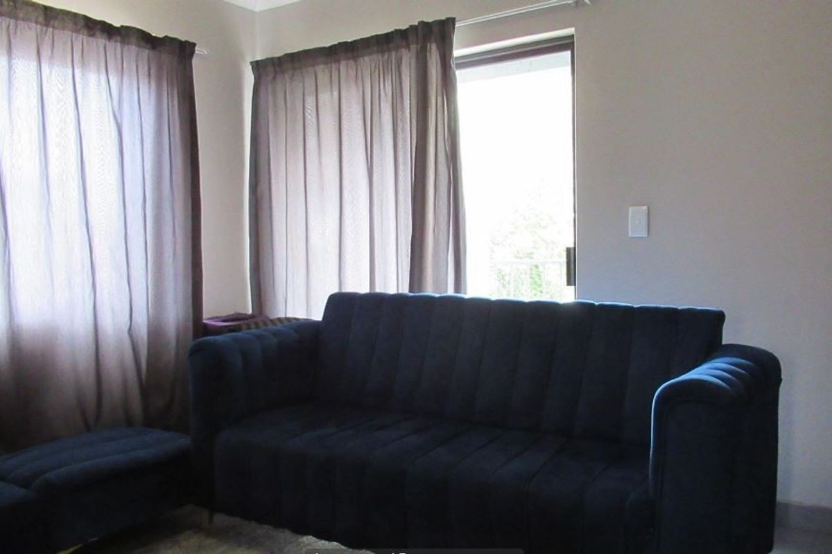 A living room area featuring a sliding glass door providing natural light and access to an outdoor space.