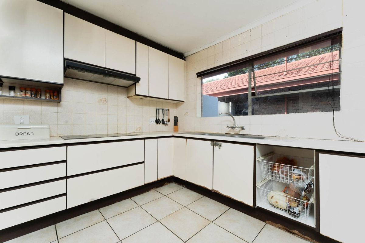 A dated kitchen featuring laminate cabinetry, a tiled backsplash, and ceramic flooring, offering significant potential for a modern renovation.