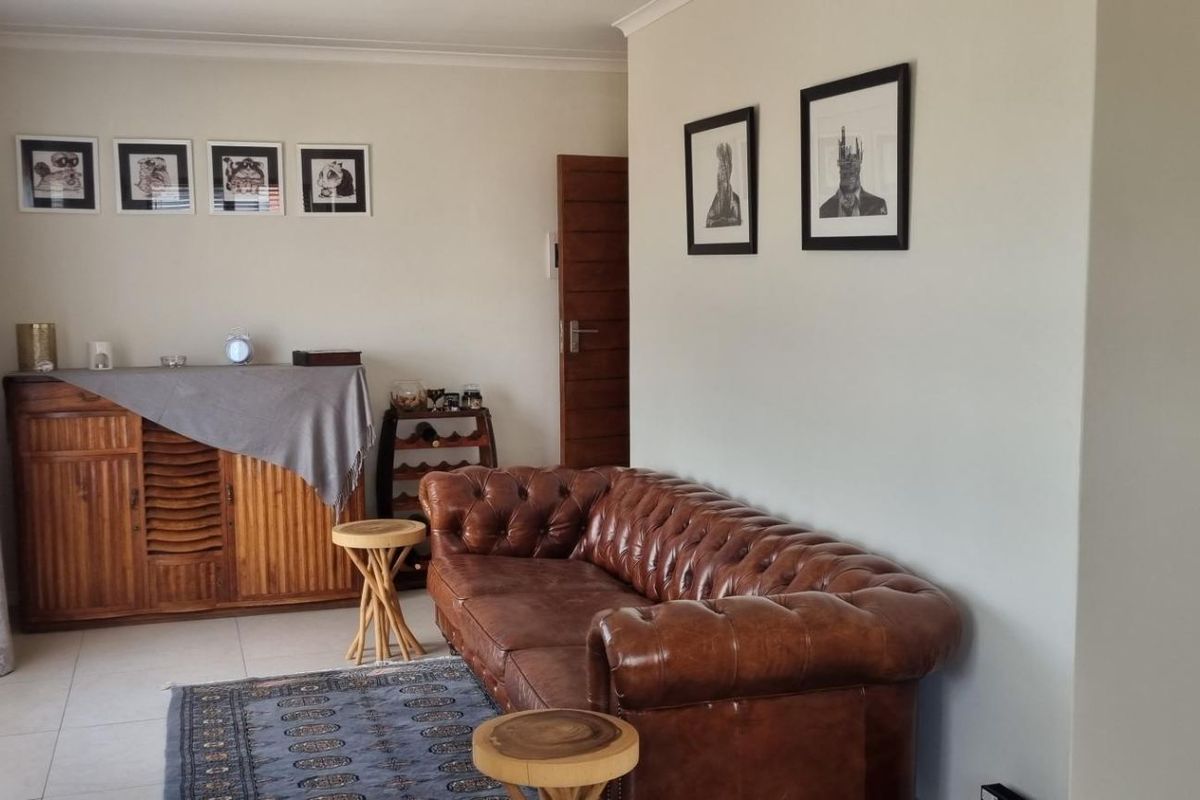 A well-maintained living room featuring neutral walls, tiled flooring, and classic cove cornicing, providing a comfortable and inviting space.