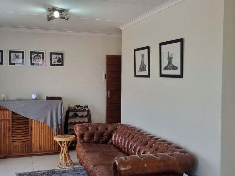 A comfortable living room featuring tiled flooring and neutral wall finishes, providing a functional and well-maintained space for relaxation.